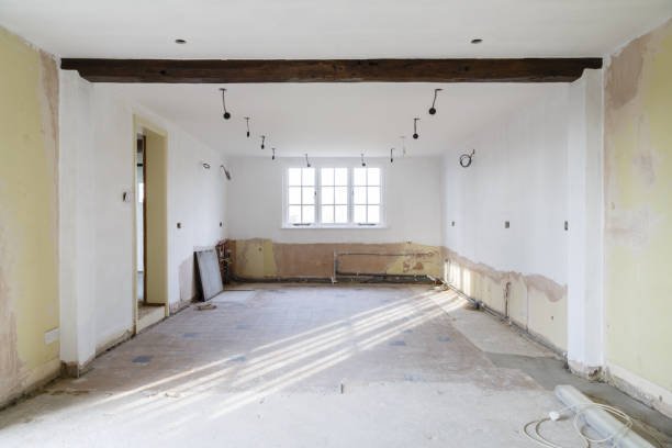 A room undergoing renovation, featuring poorly executed ceiling and wall work, highlighting shoddy remodeling efforts.