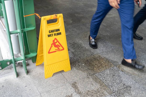 A man in a suit walks past a wet floor sign, indicating a water damage restoration area.