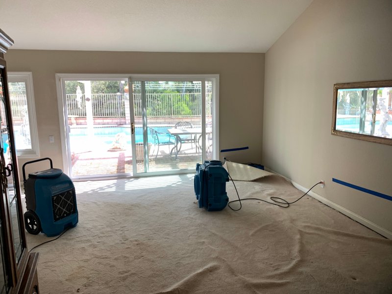 A room featuring a pool and a vacuum cleaner, highlighting carpet water damage restoration efforts.