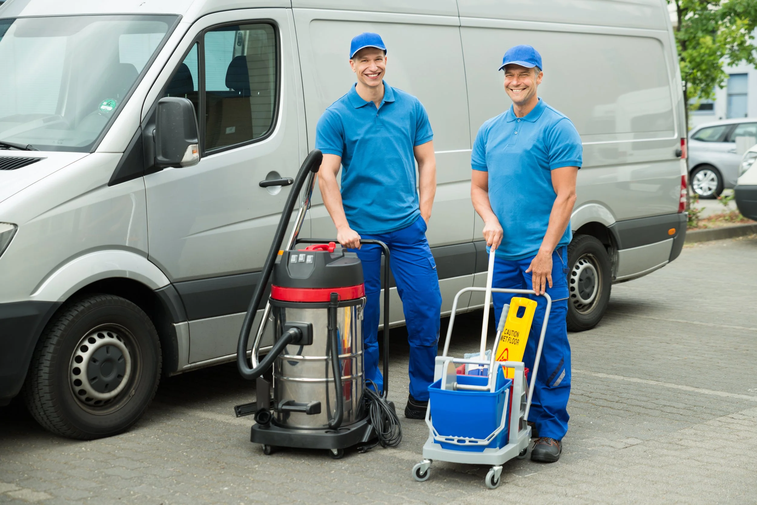 Expert Flood Cleanup Service workers are standing by a van with their equipment