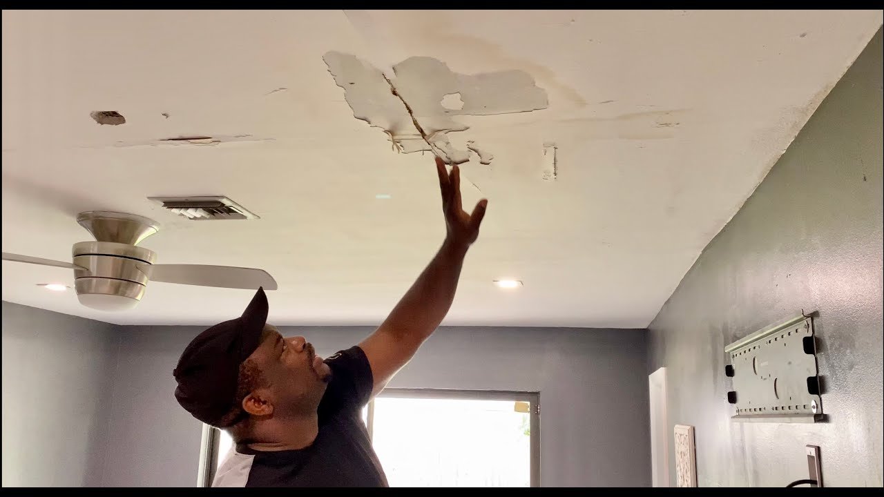 Contractor performing ceiling water damage repair after plumbing or roof leak