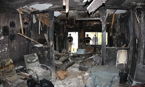 Emergency Fire Damage Restoration Service team repairing burned roofing and attic area