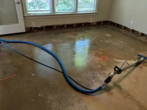 A professional crew uses industrial extractors and drying equipment to perform urgent water damage restoration in a severely flooded commercial hallway.